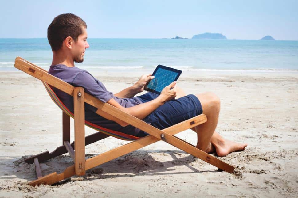Hombre Con Su Tablet Sentado En La Playa En Vacaciones